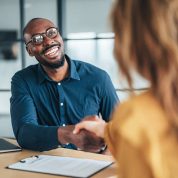 istockphoto-2255727892-612x612 Business people shaking hands in the office. Two entrepreneurs shaking hands on job interview in board room. Corporate business team discussing new agreement. Female manager discussing new project with her colleagues. Company owner on a meeting with new employee in her office.
